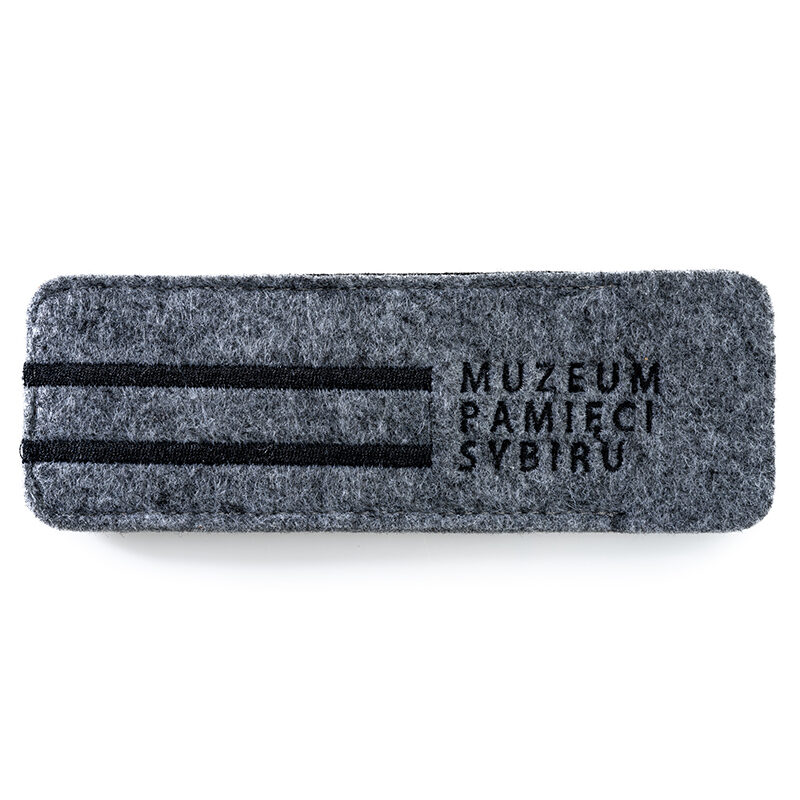 Zdjęcie: Na białym etui na długopis z filmu. Na prawie całej długości wyszyte logo Muzeum Pamięci Sybiru.