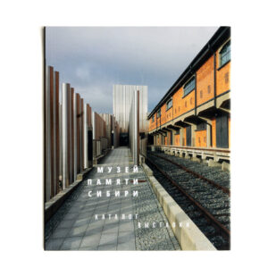 Zdjęcie: Na białym tle okładka katalogu wystawy stałej. Na okładce zdjęcie wejścia głównego do muzeum. Na dole białym literami tekst w języku rosyjskim "Muzeum Pamięci Sybiru Katalog wystawy".